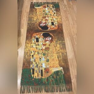 This product is a reversible fringe scarf The Kiss by Gustav Klimt. 
AI
